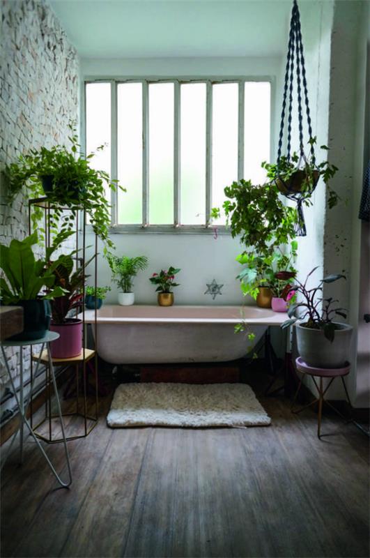 Vihreä kylpyhuoneen kylpyammeessa ikkunan edessä Maalaistyylinen kylpyhuone, jossa on paljon vihreitä kasveja